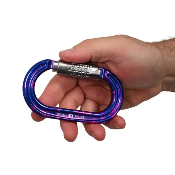 A person's hand holding a blue and pink Omega Pacific Raider+ Aluminum Keylock 3-Stage Quik-Lok Ultra-Violet with a silver locking mechanism.