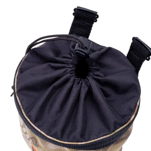 A close-up of an Ape Canyon Outfitters Saddle Pouch Kryptek Highlander with a black top and beige bottom. The pouch is cinched at the top and has black straps with plastic buckles attached. The material appears to be durable fabric.