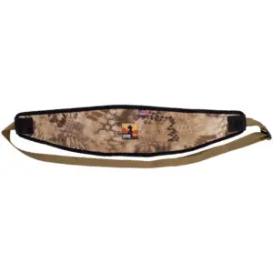 A camouflaged rifle sling featuring a blend of beige and brown patterns. The padded section has a small logo with an American flag design and a silhouette of a person. The Ape Canyon Outfitters Lazy Hunter Band Kryptek Highlander has adjustable straps in a solid, light brown color.