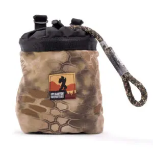 A camouflage-patterned chalk bag with a black drawstring top and a textured climbing rope attachment. The front of the bag features a logo with an image of a climber and the text "APE CANYON OUTFITTERS CLIMBING LINE AND SADDLE POUCH COMBO" beneath it.