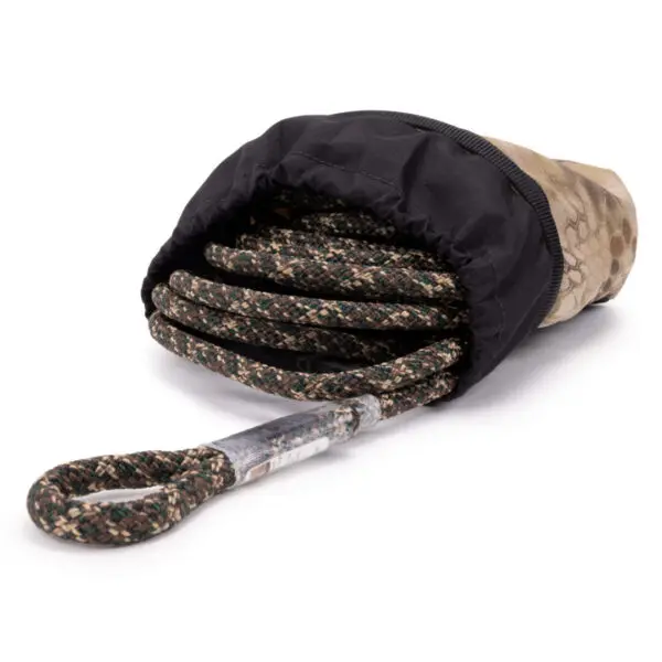 A coiled rope with a camouflage pattern partially encased in a black fabric cover, with one looped end of the rope visible in front. The fabric cover also appears to have a camouflage print near the opening. This is the Ape Canyon Outfitters Saddle Pouch Kryptek Highlander.