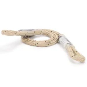 A coiled, beige-colored, synthetic *Ape Canyon Outfitters 6mm TRC Eye to Eye Hitch Cord 23"* with two looped ends. The cord has a slightly textured surface with occasional dark specks. One end of the cord is partially wrapped in clear plastic, revealing a label with some text on it.