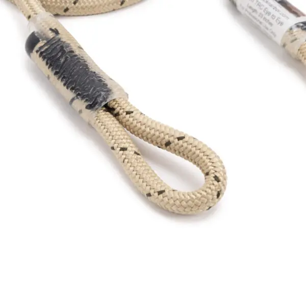A close-up of a beige braided rope with black thread woven through it. The Ape Canyon Outfitters 6mm TRC Eye to Eye Hitch Cord 23" is looped at the end and secured with black shrink wrap, making a fixed loop. Additional parts of the rope are visible in the background.