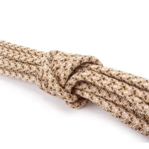 A close-up view of a neatly coiled beige and white braided Ape Canyon Outfitters 6mm Nylon Wilderness Cord, tied securely with an overhand knot. The cord has a textured surface, creating a pattern of interwoven fibers. The background is plain white, focusing attention on the cord and knot.