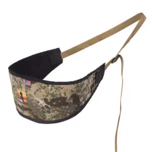 Ape Canyon Outfitters Lazy Hunter Band Obskura Transitional is a camouflaged military-style strap with an American flag patch and another colorful patch. The strap has a padded section with black mesh lining and an adjustable tan strap. It also includes a small attachment loop.
