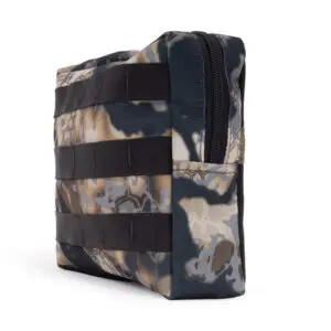 The Ape Canyon Outfitters One Stick Saddle Pouch Obskura Skyfall is a compact, rectangular camouflage pouch with a zipper on the top. The case features an abstract camouflage pattern in shades of brown, beige, and gray, with black horizontal straps sewn onto the front and sides for additional attachments.