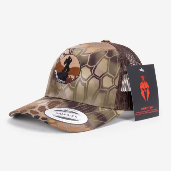 A camo-patterned Ape Canyon Outfitters Richardson Trucker Hat with a mesh back and a circular patch featuring a black horse silhouette on a brown background. The hat has a white "Snapback" sticker on the brim and a black, red, and white Kryptek brand tag attached.