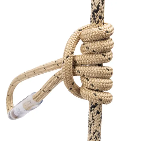 Close-up of a rope tied into a Prusik knot around another rope, primarily beige in color with black specks. The Prusik knot is secure and neatly wrapped, highlighting its braided texture. An end of the Ape Canyon Outfitters Sewn TRC Prusik Loop features a protective covering.