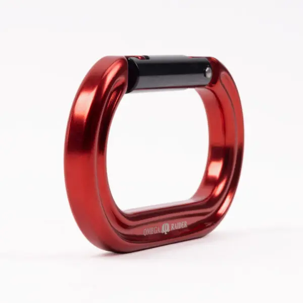 A red Omega Pacific Raider Aluminum Keylock Straight Gate - Red carabiner with a black hinge mechanism. The carabiner's design is sleek and rectangular, showcasing a polished, metallic finish. The Omega logo and model name "Raider" are printed on one side.