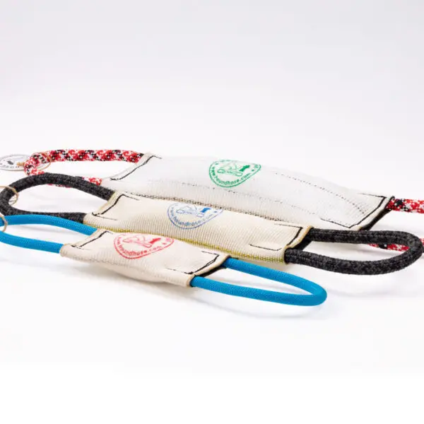 Three Hound Hose Dog Tug Toys are displayed in a line on a white background. The toys are made of durable fabric with different colored handles: blue, black/red, and black. Each toy has a circular brand logo in the center featuring various colors.