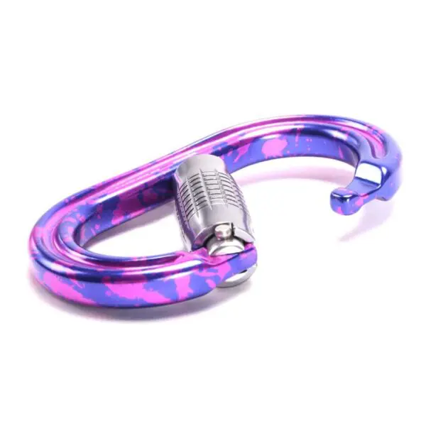 A pink and purple splattered Omega Pacific Raider+ Aluminum Keylock 3-Stage Quik-Lok Ultra-Violet with a silver locking mechanism is shown against a white background. The Omega Pacific Raider+ Aluminum Keylock 3-Stage Quik-Lok Ultra-Violet has an elegant, slightly curved shape, ideal for climbing or securing gear.