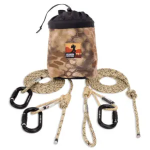 An Ape Canyon Outfitters 8mm Resc Tech Saddle Hunting Combo with 3 Stage Quick Lock Carabiners, featuring a camo-patterned gear bag labeled "Ultimate Hunters," is positioned centrally. The open bag reveals two beige and black ropes with carabiners attached, extending outwards. The ropes are coiled and neatly placed on either side of the bag, showcasing the setup.