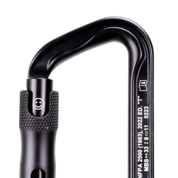 A close-up of a black Omega Pacific Standard D Aluminum Keylock 3-Stage Quik-lok NFPA carabiner with a screw-gate mechanism. Engraved text is visible on the carabiner's spine, displaying specifications and standards, including "NFPA 2500" and "2022 ED." alongside other technical details.