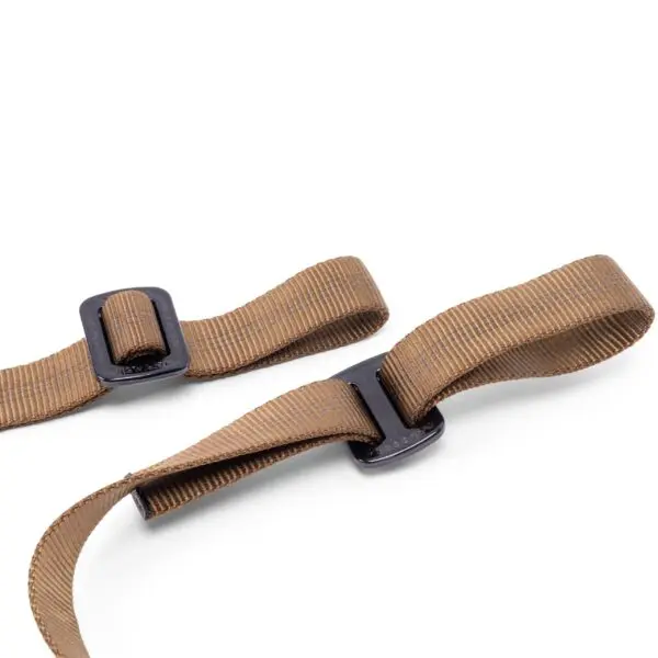 Two angled brown fabric straps with black plastic buckles, the Ape Canyon Outfitters Adjustable 3 Step Aider, are shown against a white background. The straps appear to be adjustable, with one strap threaded through its respective buckle, forming a loop.