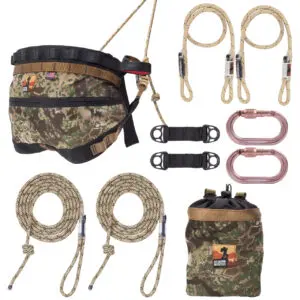 An assortment of Ape Canyon Outfitters Wood Deluxe Saddle Kit Transitional gear, including a camouflage harness, two lanyards, ropes, connectors, and a camouflage pouch. All items are displayed neatly against a white background, featuring a consistent camouflage design and high-quality materials.