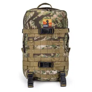 An Ape Canyon Outfitters Conclave Pack Highlander Skyfall (Copy) with multiple straps and buckles. It features a top handle and a patch with a silhouette logo on the upper front. The design includes MOLLE webbing for attaching additional gear.