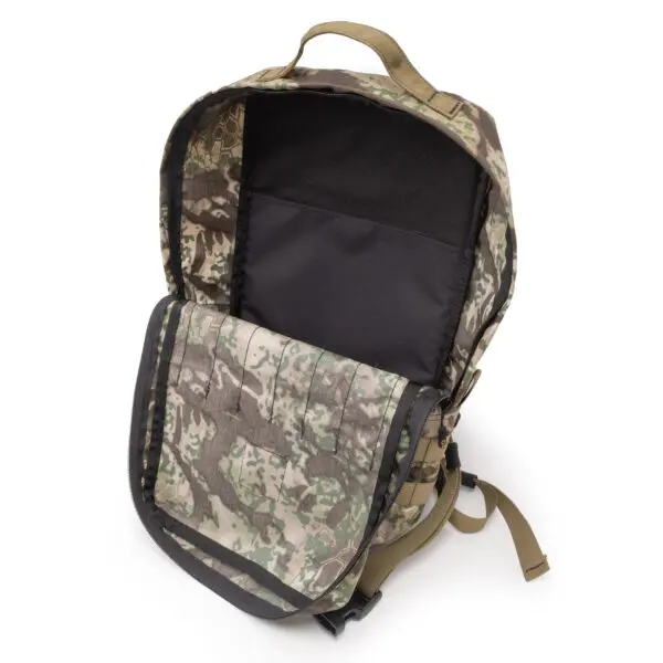 A camouflaged military-style backpack with an open top zipper and flap, displaying the spacious interior compartment. The bag features adjustable shoulder straps and a sturdy handle at the top. The camouflage pattern includes various shades of green, brown, and beige. The Ape Canyon Outfitters Conclave Pack Transitional is perfect for any adventure, offering both functionality and style.