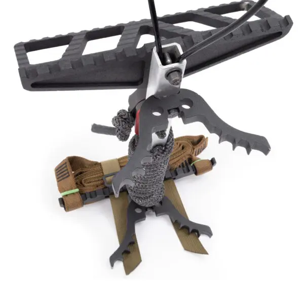 The Scout One Stick is a compact, heavy-duty tree climbing device featuring jagged metal grips and a rugged woven strap system. Its design includes an anti-slip platform and multiple secure attachment points, aimed at providing stability and safety for climbers.