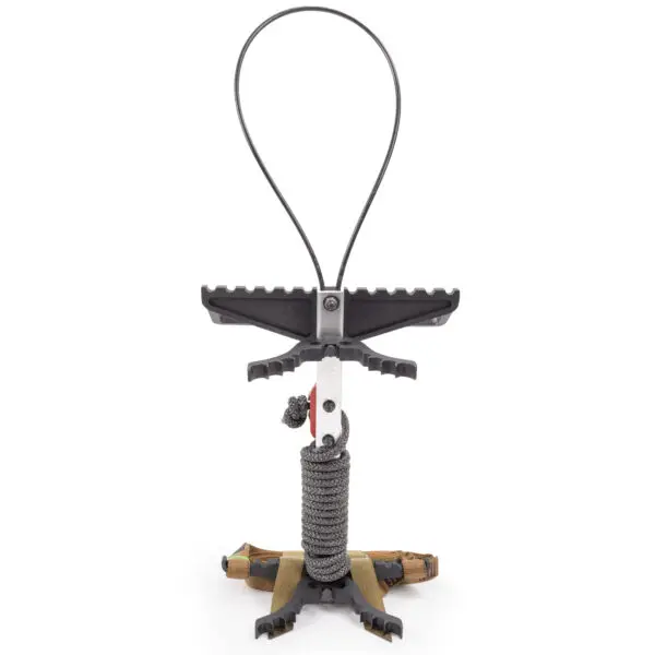 A close-up image of the Scout One Stick, a modern slingshot with a sleek black and silver design. It features a padded ergonomic grip wrapped in paracord, a flat rubber band, and a stable base with an attached camo wrist brace.