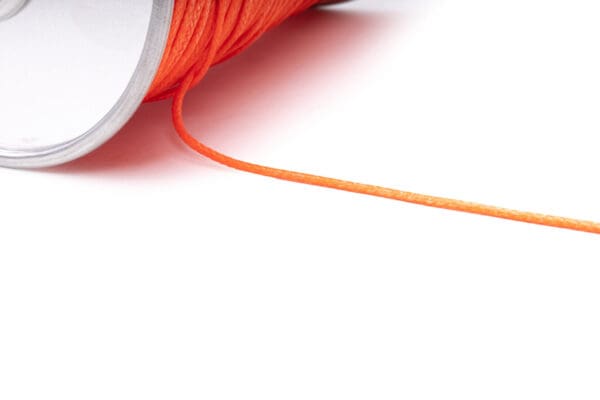 Close-up of an Ape Canyon Outfitters One Stick Retrieval Donut on a white background. The string is partially unrolled, extending diagonally across the image. The roll appears to have a metallic core.