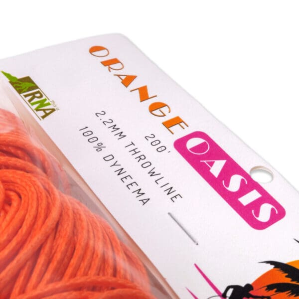 Close-up of a package of orange throwline, labeled "Ape Canyon Outfitters 2.2mm Orange Oasis." The specifications on the label indicate it is 2.2mm thick, 200 feet long, and made of 100% Dyneema. The yarn is partially visible in the bottom left corner.