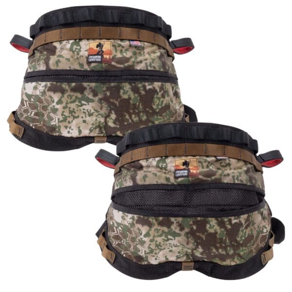Two Ape Canyon Outfitters Wood Deluxe Saddle Obskura Transitional harnesses with camouflage patterns are shown. They feature multiple straps, buckles, and patches, including one with a flag and another with a dog logo. The harnesses appear designed for outdoor or military use.